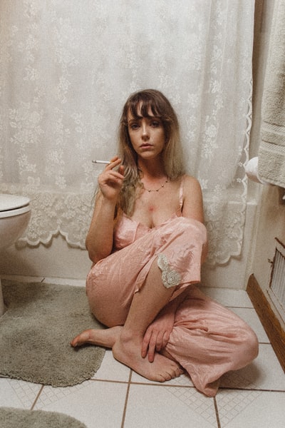 坐着的女人穿睡衣裤子卫生间内吸烟
